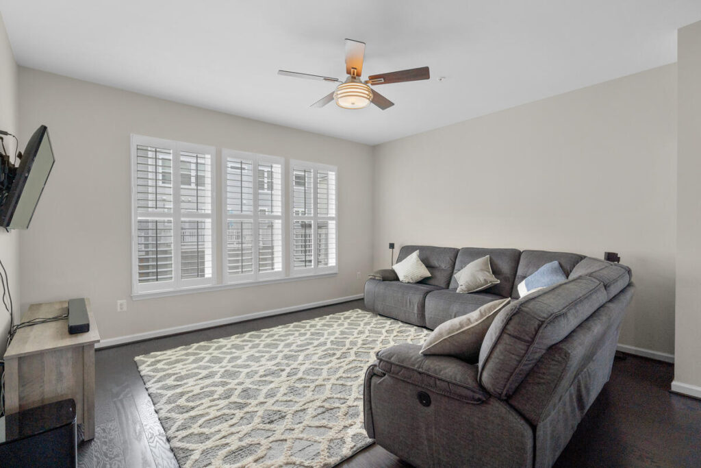 Bright neutral living room with large windows and comfortable seating